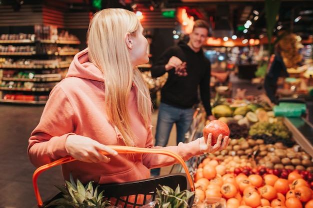 Jovem casal na mercearia levando frutas