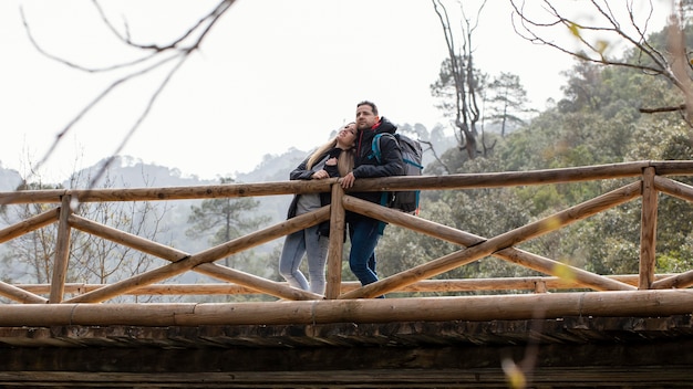 Foto jovem casal na natureza sentado na ponte