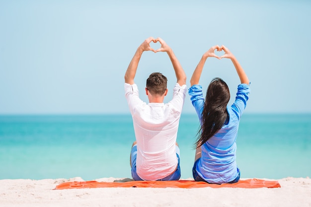 Jovem casal na praia branca durante as férias de verão. Família feliz desfrutar de sua lua de mel