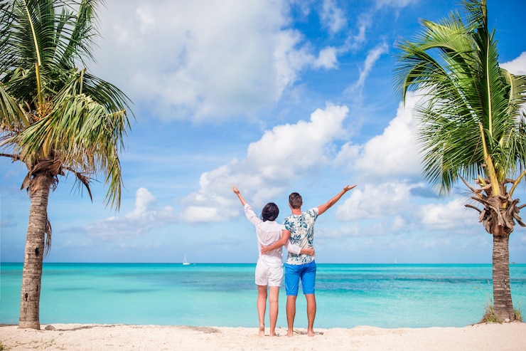 Foto jovem casal na praia branca. família feliz em férias de lua de mel