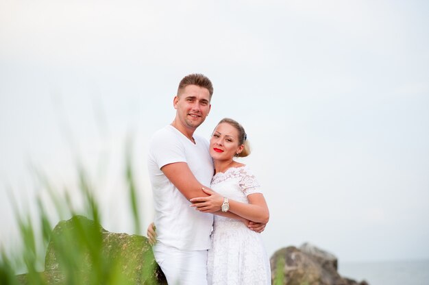 Jovem casal nas rochas no mar