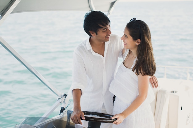 Jovem casal navegando em um iate no oceano índico