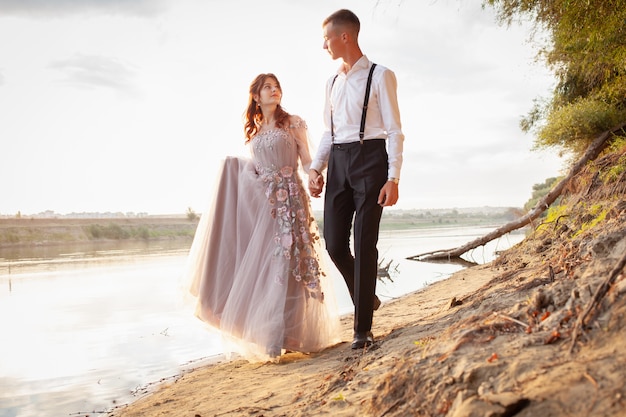 Jovem casal no dia do casamento à beira do lago