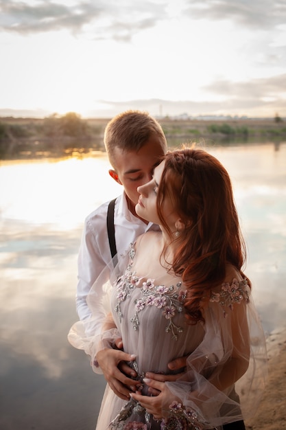 jovem casal no dia do casamento à beira do lago