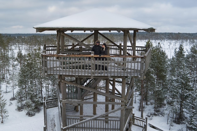Jovem casal no inverno em uma torre de observação no pântano de viru foto de drone