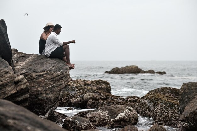 Jovem casal no oceano puro de pedra