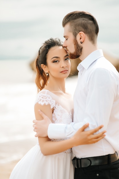 Jovem casal noivo com a noiva em uma praia em uma caminhada de casamento