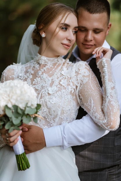 Jovem casal o noivo em um terno xadrez e a noiva em um vestido branco chique