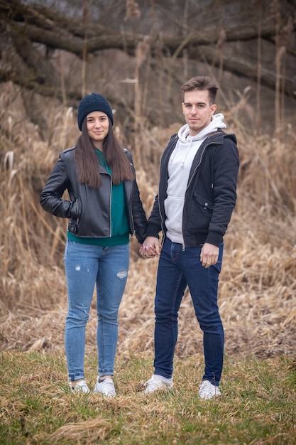 Jovem casal parado na natureza em um dia de inverno