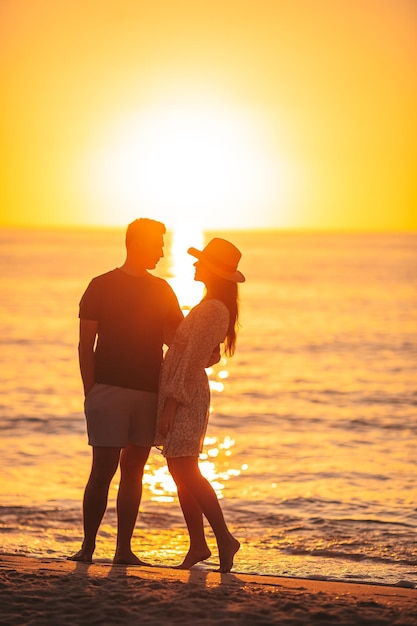 Foto jovem casal passando tempo juntos na praia ao pôr do sol