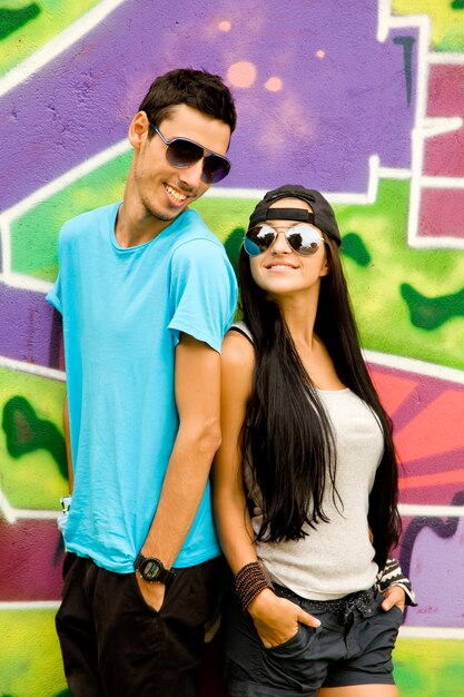 Jovem casal perto da parede do graffiti.