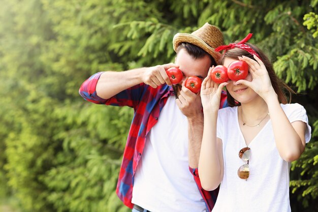 jovem casal plantando tomates orgânicos