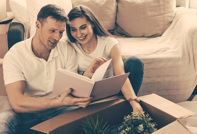 Jovem casal procurando uma foto de família em um apartamento novo