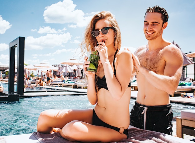 Jovem casal quente descansando na piscina.