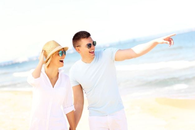 Jovem casal romântico caminhando na praia