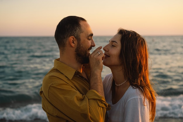 Jovem casal romântico dançando girando pelo mar Seascape ao pôr do sol com lindo céu Casal romântico na praia ao pôr do sol dourado Casal de amantes se divertindo na praia