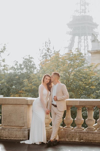 Jovem casal romântico em frente à Torre Eiffel