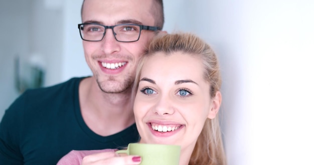 jovem casal romântico feliz desfrutando de café da manhã pela janela em sua casa de luxo