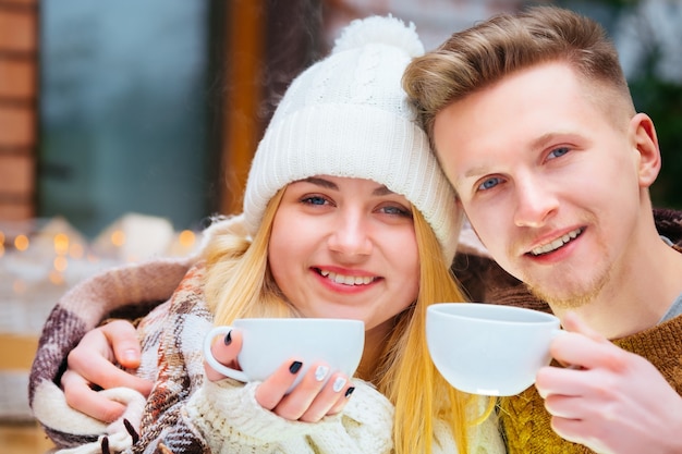 Jovem casal romântico feliz sentado em um café de mãos dadas