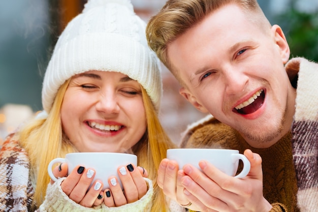 Jovem casal romântico feliz sentado em um café de mãos dadas