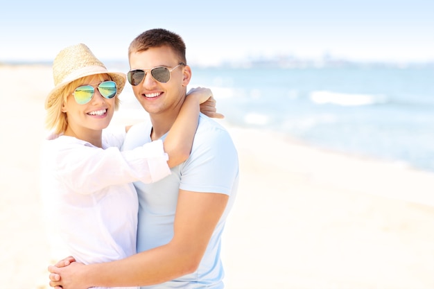 jovem casal romântico se abraçando na praia e copie o espaço
