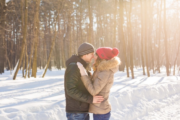 Jovem casal se abraçando e beijando no parque no inverno.