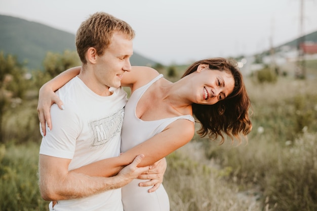 Jovem casal se beijando e se abraçando ao ar livre no verão.