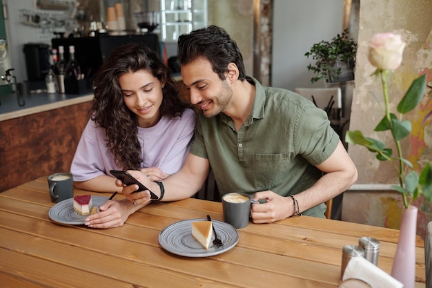 Jovem casal se comunicando em bate-papo por vídeo em smartphone realizado por cara