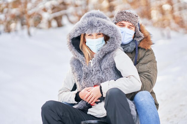 Jovem casal se divertindo na neve, usando máscara. foto de alta qualidade