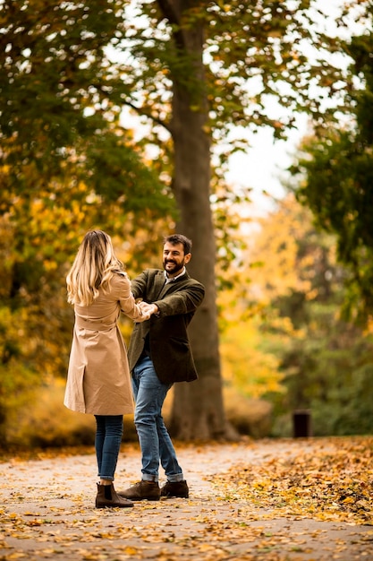 Jovem casal se divertindo no parque outono