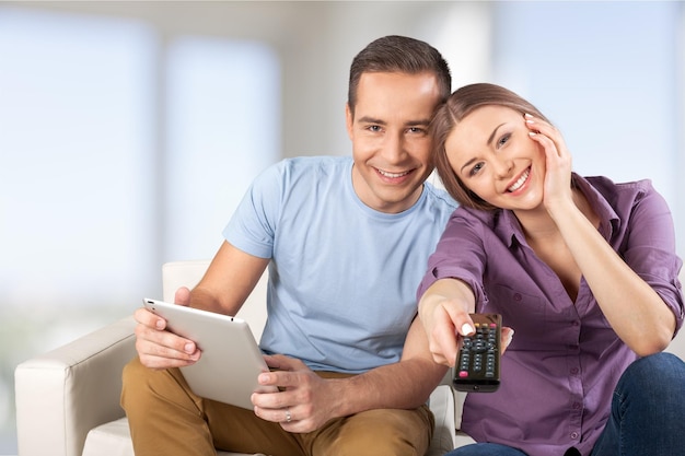 Jovem casal segurando tablet digital em segundo plano