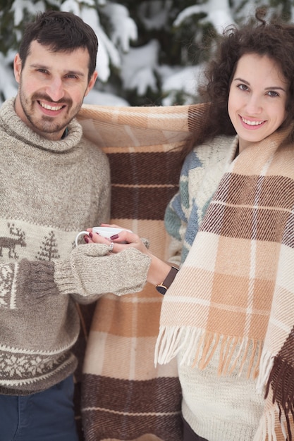 Jovem casal segurando um chá quente em winter park