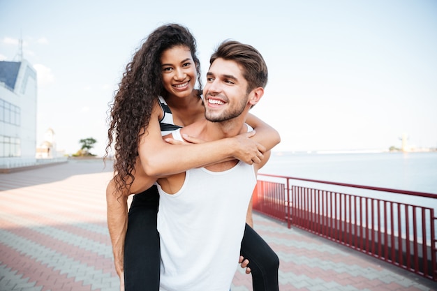 Foto jovem casal sorridente caminhando e se divertindo