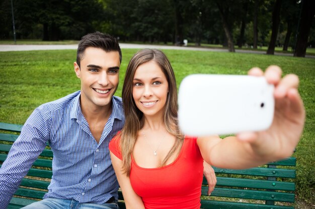 Jovem casal sorridente tomando um retrato de selfie