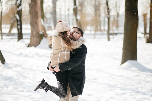 Jovem casal sorrir e beijar no parque no inverno