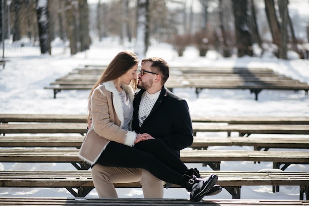 Jovem casal sorrir e beijar no parque no inverno