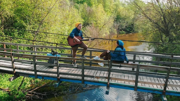 Jovem casal tendo encontro romântico na ponte na floresta