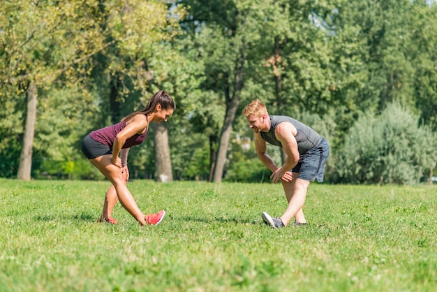 Jovem casal tendo exercício no parque