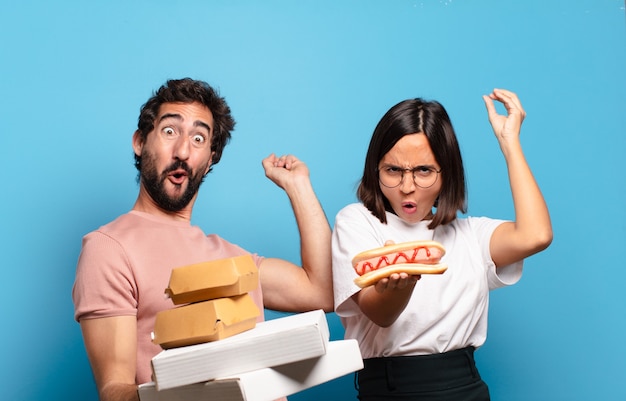 Jovem casal tendo levar fast food para casa.