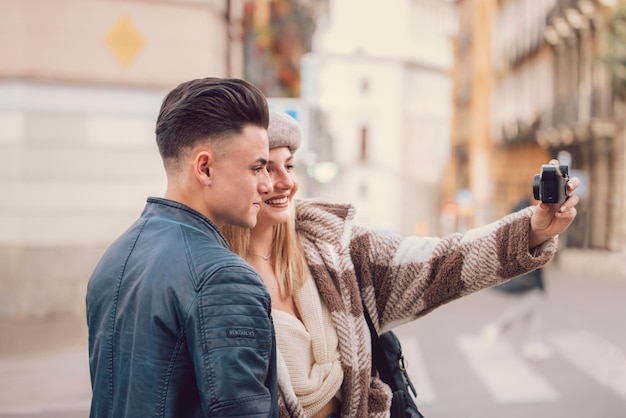 Foto jovem casal tira uma foto juntos enquanto visita a cidade