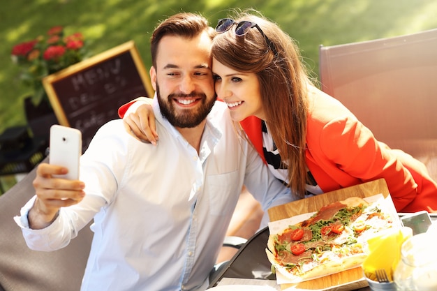 jovem casal tirando uma selfie em um restaurante