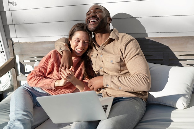 Foto jovem casal usando laptop juntos lá fora