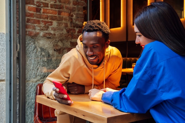 Jovem casal usando smartphone em uma cafeteria