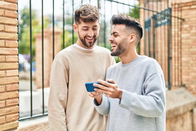 Jovem casal usando smartphone juntos na rua