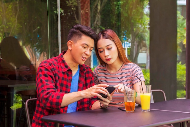 Jovem casal usando um smartphone juntos no café