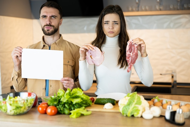 Jovem casal vegetariano está mostrando que não gosta de comer carne e prefere vegetais frescos