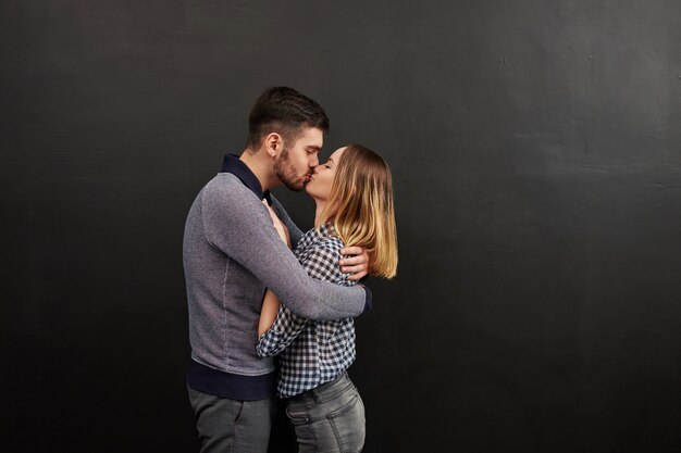 Foto jovem casal vestindo roupas casuais, em pé e olhando um para o outro. foto de estúdio