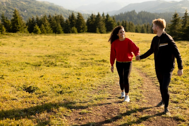 Jovem casal viajando juntos e caminhando nas montanhas