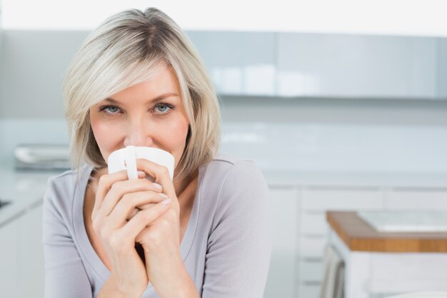 Jovem casual tomando café em casa