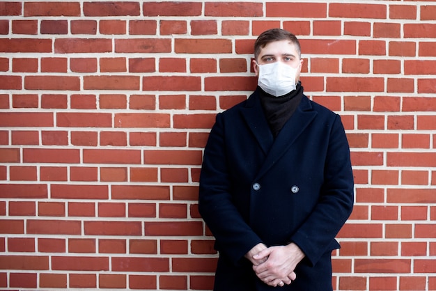 Jovem caucasiano perto de seu escritório usando máscara cirúrgica para proteger do coronavírus covid-19 covid 19 virus
